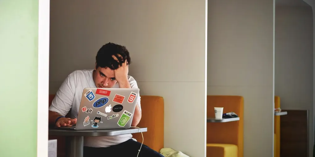 man in white shirt using macbook pro